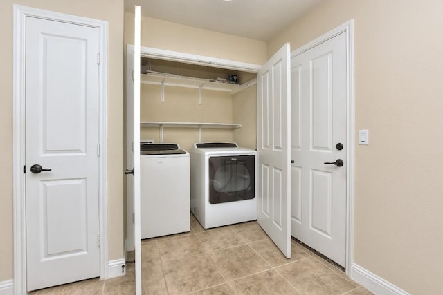 clothes washing area with light tile patterned floors and washing machine and dryer