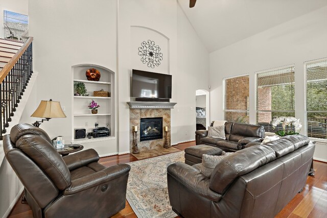 2621 Golden Gate Park, Austin, TX 78732 - living room featuring hardwood / wood-style flooring, a tiled fireplace, high vaulted ceiling, and built in shelves