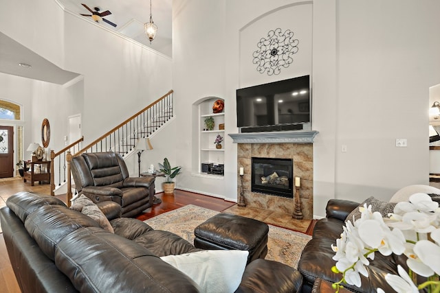 2621 Golden Gate Park, Austin, TX 78732 - living room featuring hardwood / wood-style floors, a towering ceiling, built in features, and a tile fireplace