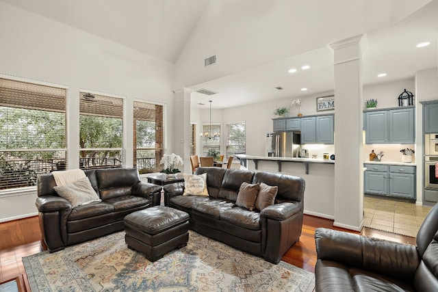 2621 Golden Gate Park, Austin, TX 78732 - living room featuring a chandelier, high vaulted ceiling, light hardwood / wood-style floors, and decorative columns