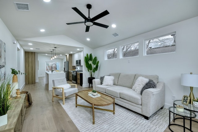 living area with visible vents, vaulted ceiling, recessed lighting, light wood-style flooring, and a ceiling fan