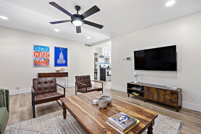 living room with hardwood / wood-style floors and ceiling fan