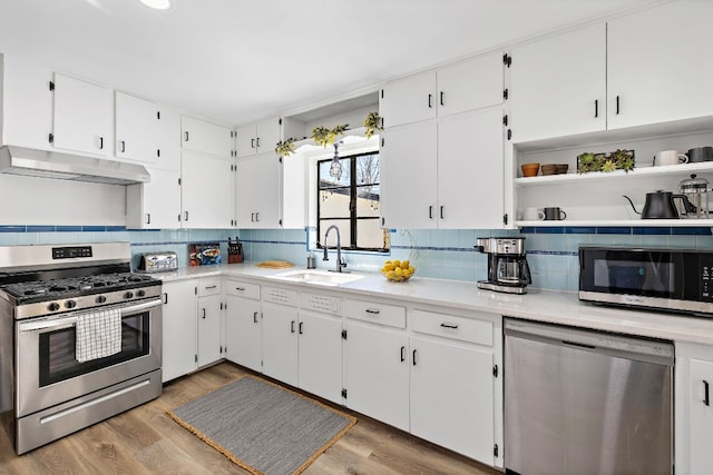 kitchen featuring stainless steel appliances, white cabinetry, and sink