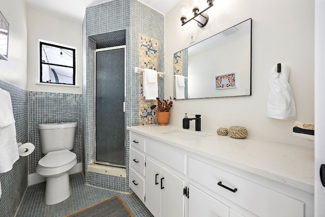 bathroom featuring tile walls, vanity, tile patterned flooring, and a shower with shower door