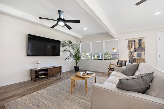 living room featuring beamed ceiling, wood-type flooring, and ceiling fan