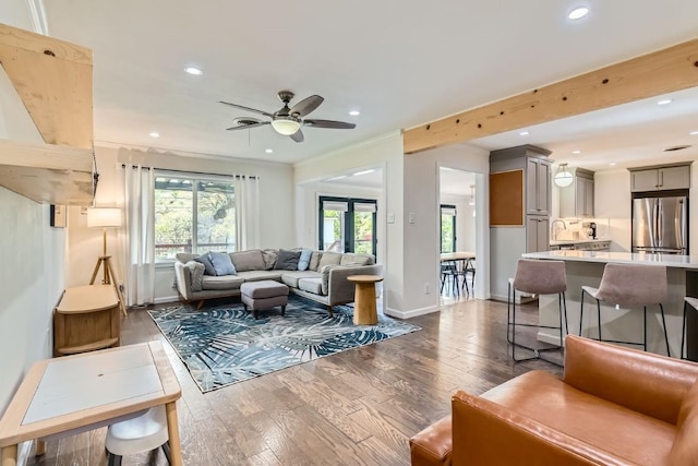 living room featuring ceiling fan, ornamental molding, and dark hardwood / wood-style floors