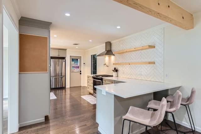 1713 Mariposa Dr, Austin, TX 78741 - kitchen featuring appliances with stainless steel finishes, wall chimney range hood, tasteful backsplash, ornamental molding, and a kitchen bar