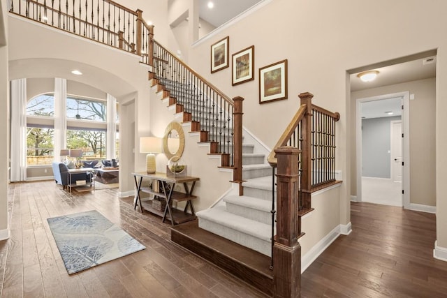 stairway featuring hardwood / wood-style flooring and a high ceiling