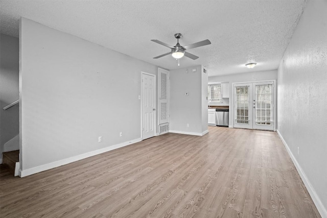 unfurnished living room featuring ceiling fan, a textured ceiling, light hardwood / wood-style floors, and french doors