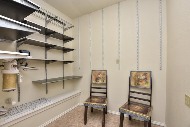 walk in closet with light tile patterned floors