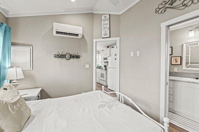 13006 Ranch Rd Unit 2341, Burnet, TX 78611 - bedroom with a wall unit AC, connected bathroom, and wood finished floors