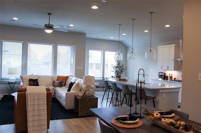 living room with ceiling fan, sink, and light hardwood / wood-style flooring