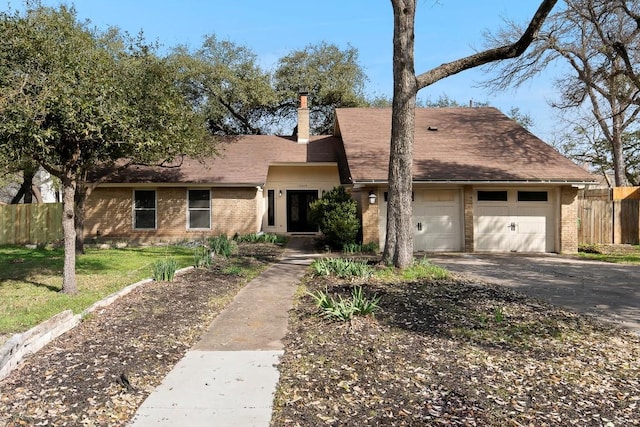 view of front of property with brick siding, an attached garage, fence, and aphalt driveway