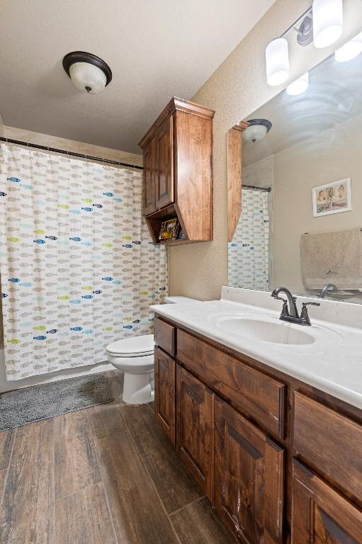 bathroom with hardwood / wood-style flooring, vanity, and toilet