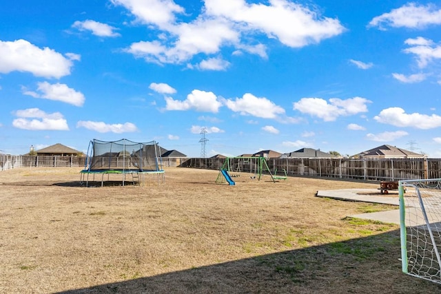 view of play area with a patio, a yard, and a trampoline