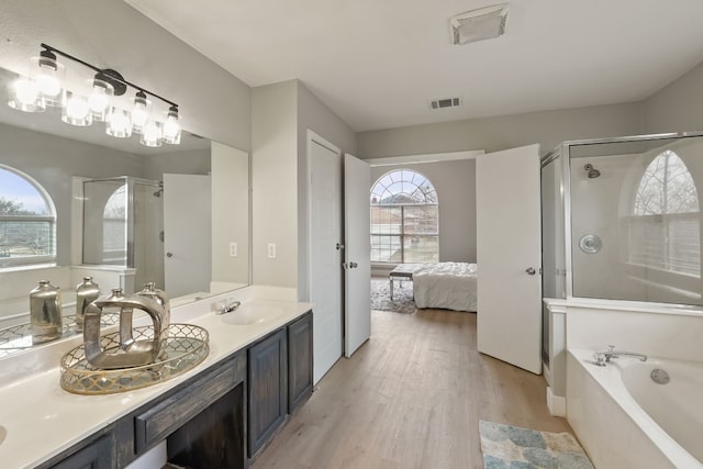 bathroom with vanity, hardwood / wood-style flooring, and shower with separate bathtub