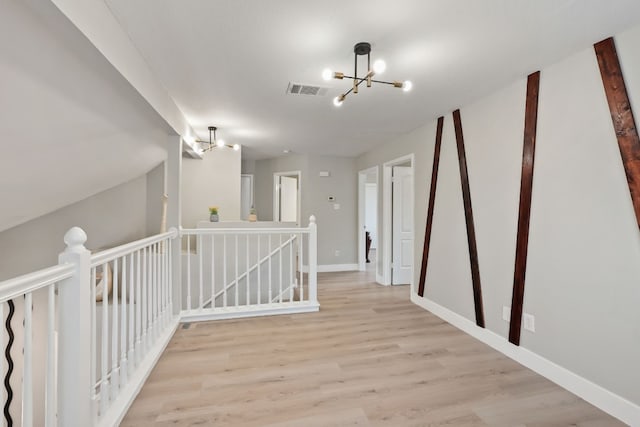 hall featuring a chandelier and light hardwood / wood-style floors