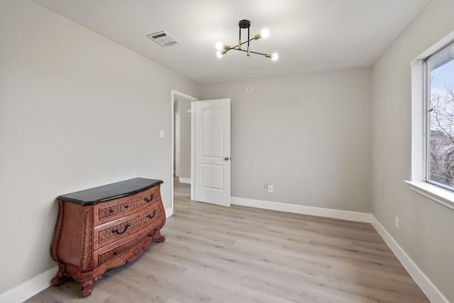 bedroom featuring a chandelier and light wood-type flooring