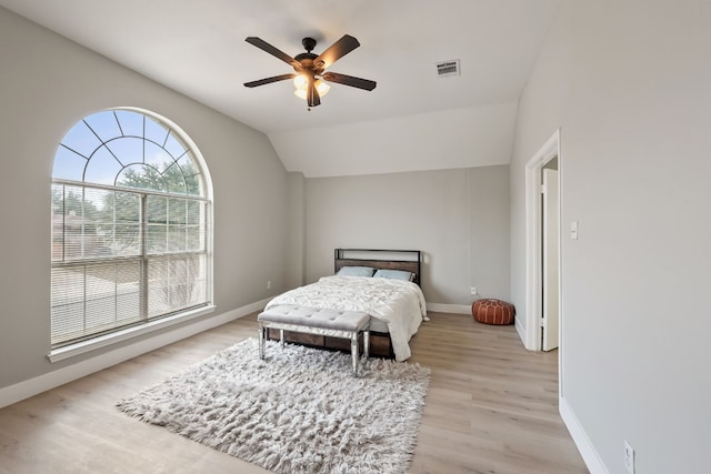 bedroom with vaulted ceiling, ceiling fan, and light wood-type flooring