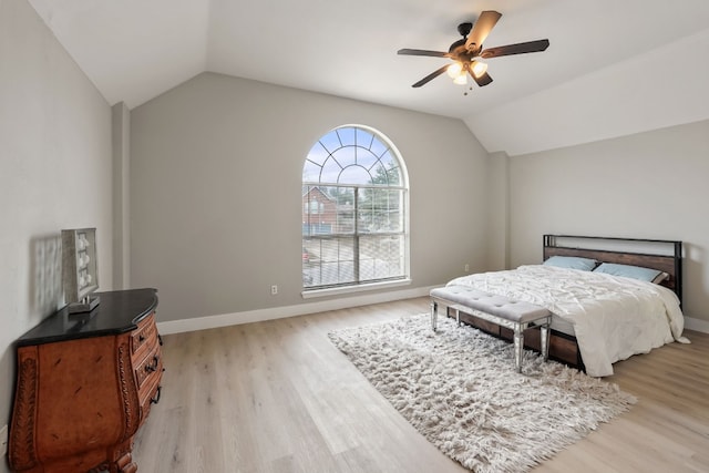 bedroom with ceiling fan, vaulted ceiling, and light wood-type flooring