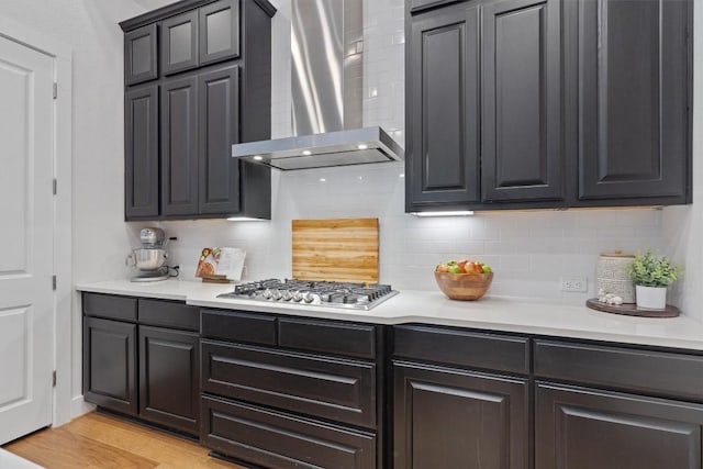 113 University Lands Dr, Liberty Hill, TX 78642 - kitchen with wall chimney range hood, stainless steel gas stovetop, decorative backsplash, and light countertops