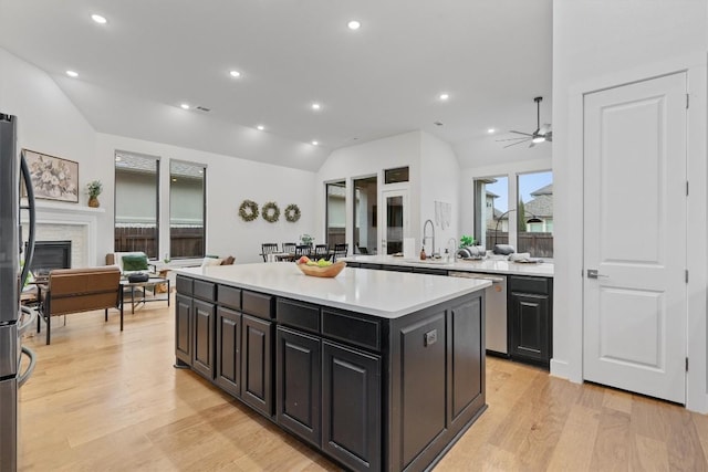 113 University Lands Dr, Liberty Hill, TX 78642 - kitchen featuring dishwasher, vaulted ceiling, a center island, a sink, and light countertops