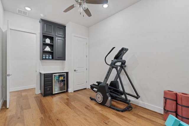 113 University Lands Dr, Liberty Hill, TX 78642 - exercise room with a dry bar, wine cooler, light wood finished floors, baseboards, and a ceiling fan