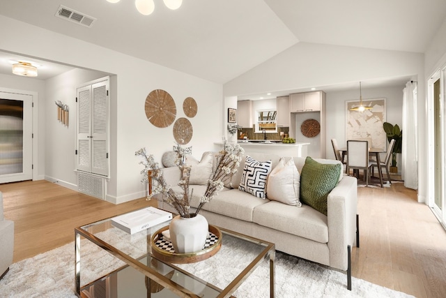 living room featuring wood-type flooring and vaulted ceiling