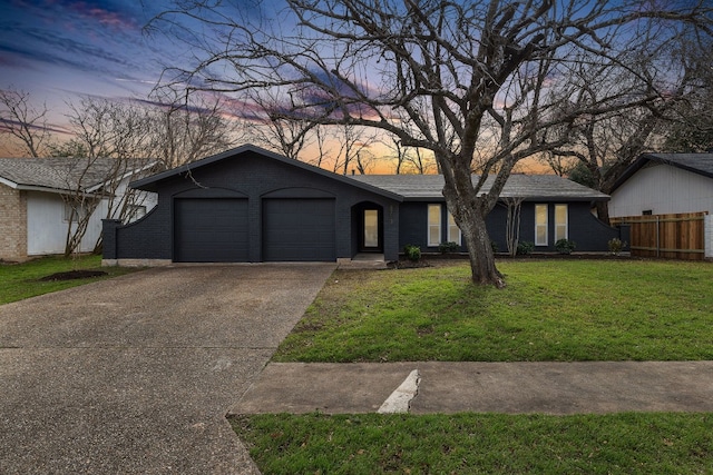 single story home featuring a yard and a garage