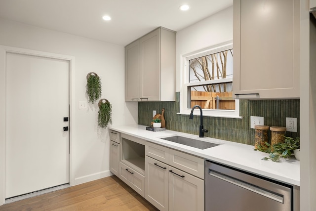 kitchen with sink, gray cabinets, dishwasher, tasteful backsplash, and light wood-type flooring