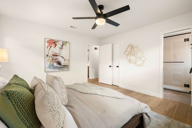 bedroom with ensuite bath, light hardwood / wood-style flooring, and ceiling fan