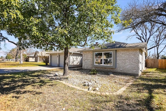 single story home featuring a garage, an outdoor structure, and a front lawn