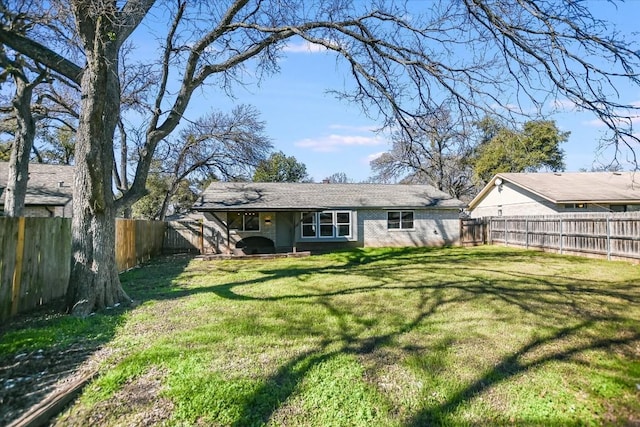 rear view of property featuring a lawn