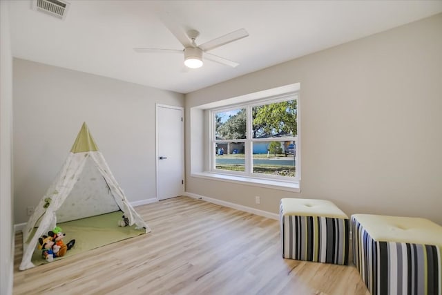 playroom with light hardwood / wood-style flooring and ceiling fan