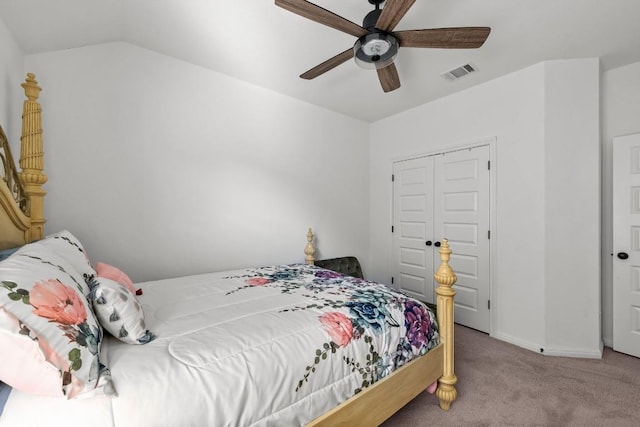 bedroom with vaulted ceiling, light colored carpet, a closet, and ceiling fan