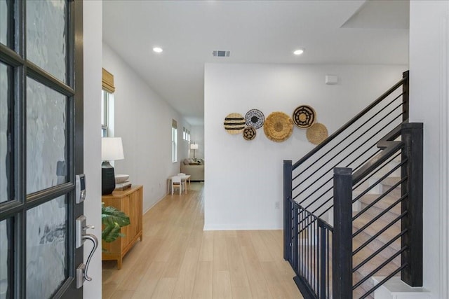 hallway featuring light wood-style floors, stairway, visible vents, and recessed lighting