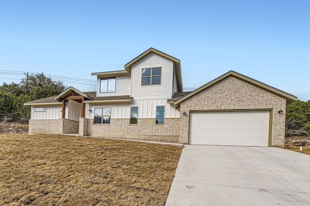 view of front of home with a garage, brick siding, board and batten siding, and concrete driveway