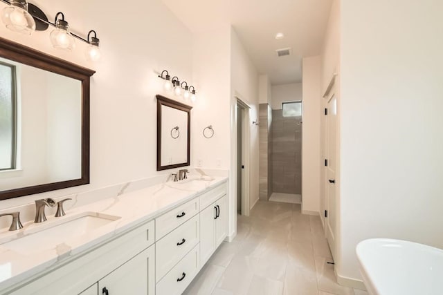 22300 Shotts Dr, Spicewood, TX 78669 - bathroom with tiled shower, double vanity, a freestanding tub, and plenty of natural light
