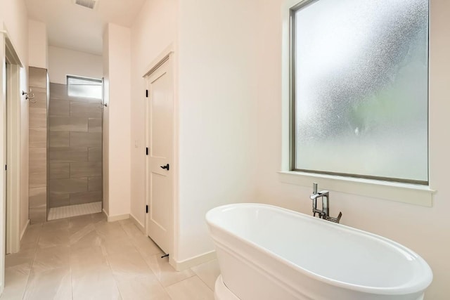 22300 Shotts Dr, Spicewood, TX 78669 - full bathroom with a freestanding tub, tiled shower, and baseboards