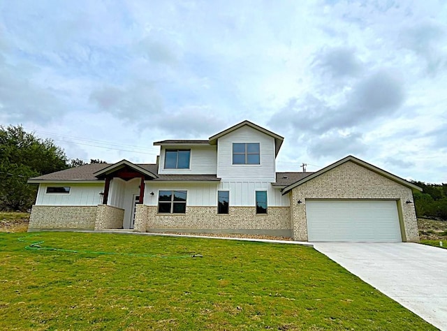 22300 Shotts Dr, Spicewood, TX 78669 - view of front facade with brick siding, an attached garage, board and batten siding, driveway, and a front yard