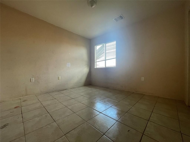 tiled spare room with vaulted ceiling