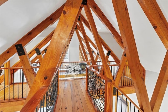 corridor with hardwood / wood-style flooring and vaulted ceiling with beams