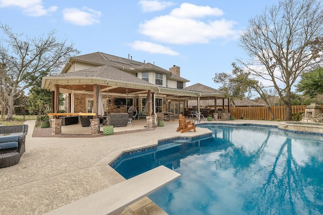 view of swimming pool featuring a gazebo, a diving board, a patio, exterior bar, and an in ground hot tub