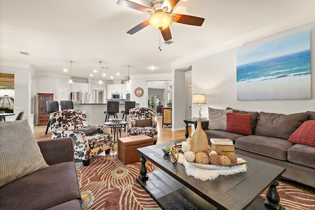 living room with crown molding and ceiling fan