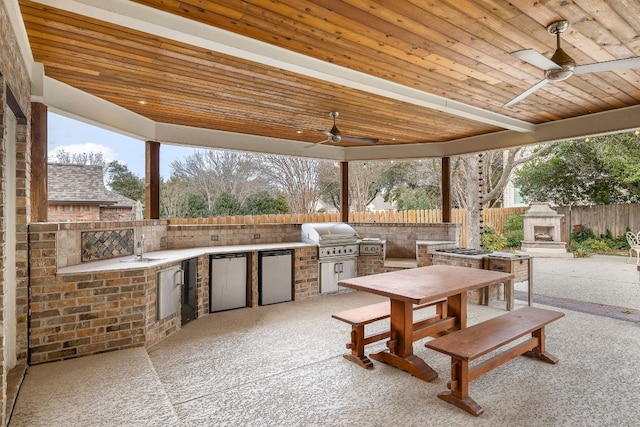 view of patio / terrace featuring an outdoor fireplace, a grill, sink, exterior kitchen, and ceiling fan