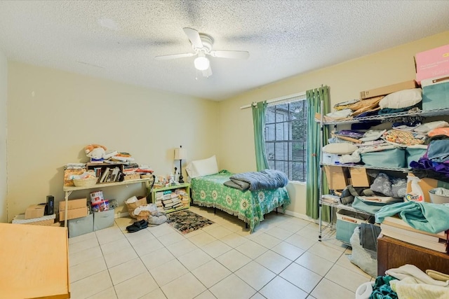 tiled bedroom with ceiling fan and a textured ceiling