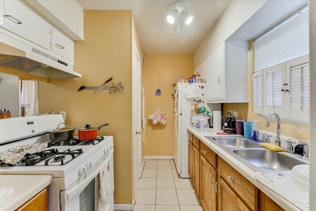 kitchen featuring light tile patterned flooring, sink, white cabinets, and white appliances