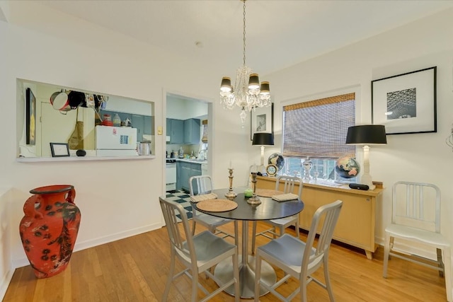 dining space with an inviting chandelier and light hardwood / wood-style floors