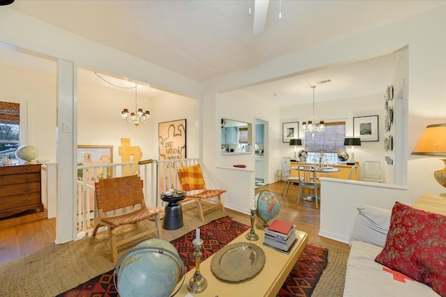 living room with hardwood / wood-style flooring, a healthy amount of sunlight, and a chandelier