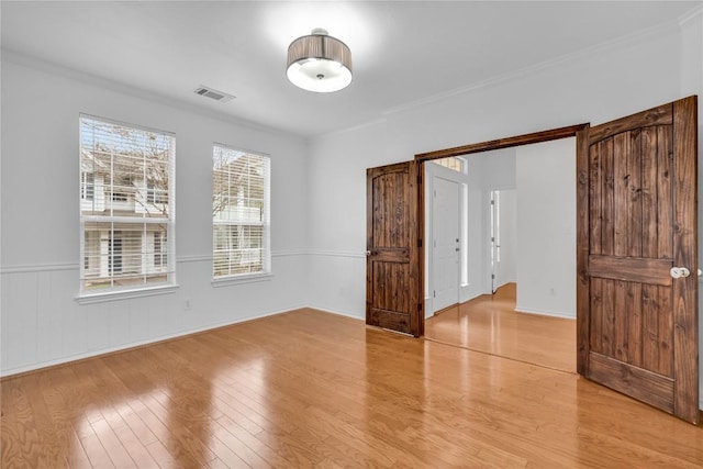 unfurnished room with crown molding and light hardwood / wood-style floors